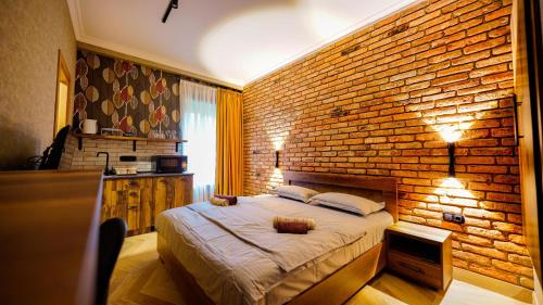第比利斯Anbani Apartments - City Center的一间卧室设有砖墙和一张床