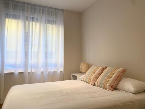 毕尔巴鄂Precioso apartamento junto a Casco Viejo的卧室配有白色的床和窗户