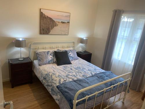 沃勒格尔Elmsford Cottage的一间卧室配有一张带蓝色床单和枕头的床。
