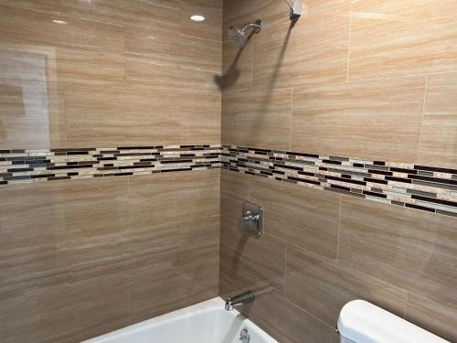 拉蓬特Industry Inn & Suites的带浴缸、卫生间和盥洗盆的浴室