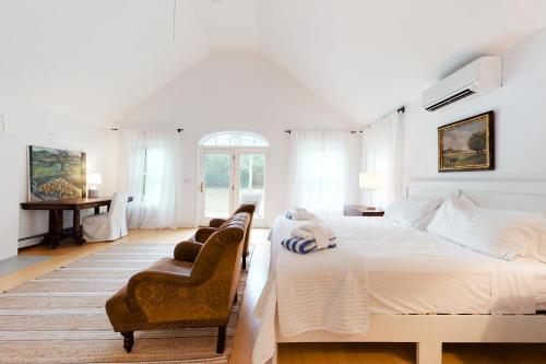 West TisburySunlit Serenity的白色卧室配有一张大床和椅子