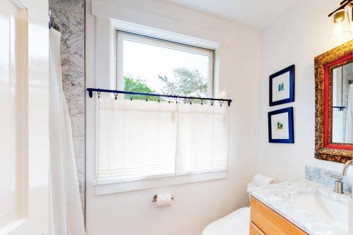 West TisburySunlit Serenity的带淋浴帘和窗户的浴室