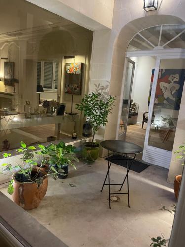 布洛涅-比扬古MAISON STANDING PROCHE ROLAND GARROS et JO 2024的一间房间,地板上摆放着桌子和盆栽植物