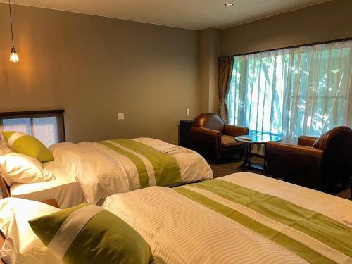 长崎和みの宿　おりがみ的酒店客房设有三张床和窗户。