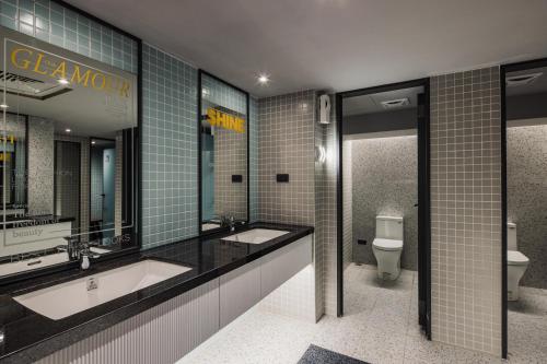 台中市悦乐旅店- 台中站前的一间带两个盥洗盆和卫生间的浴室