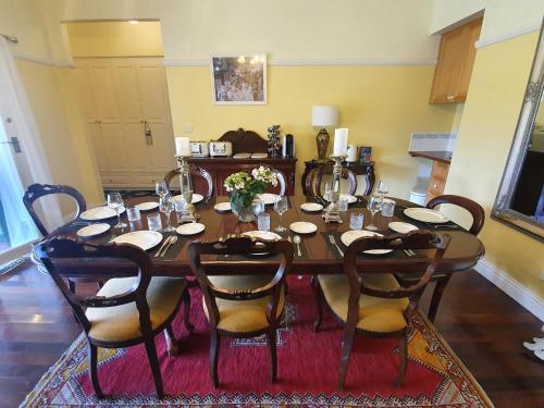 希尔斯维尔Rosebank Guesthouse的用餐室配有桌椅