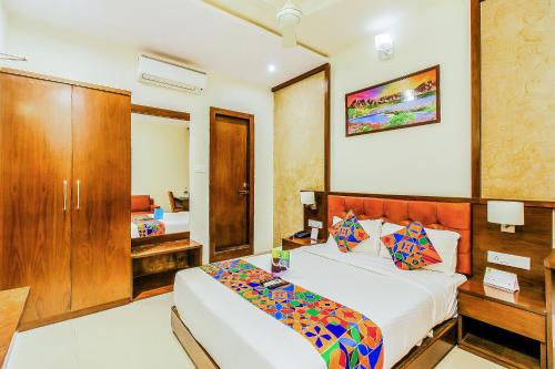 孟买FabHotel Empire Suite的一间卧室配有一张床、一张桌子和一张床