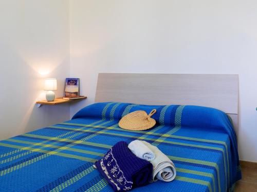 萨尔维Casa Barzò - surrounded by olive trees的一张带毛巾的蓝色床和一顶帽子