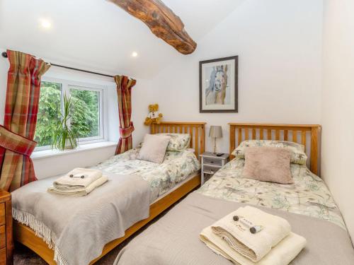 麦克尔斯菲尔德Fox Bank Cottage的一间卧室设有两张床和窗户。