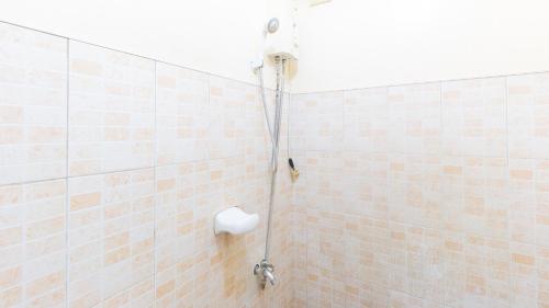 UrdanetaRedDoorz @ Goldland Spring Resort Urdaneta City的一间带淋浴的浴室和瓷砖墙