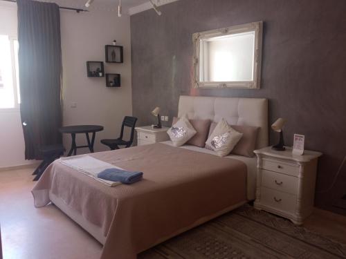 拉巴特Agréable appartement的一间卧室配有一张床、一张桌子和一个窗户。
