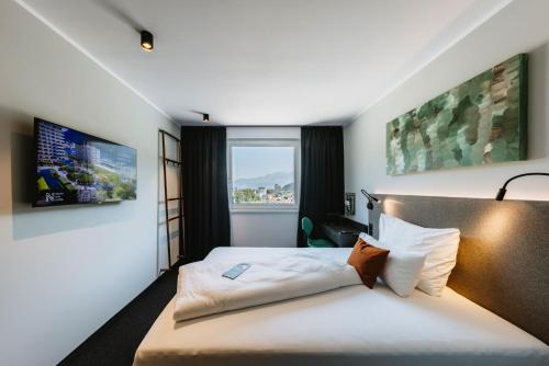 费尔德基希NIGHT INN Hotel Bahnhofcity Feldkirch的酒店客房设有床和窗户。