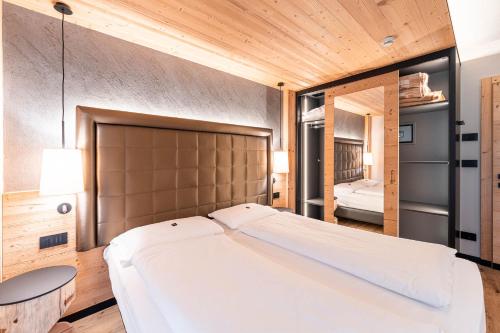 坎皮泰洛迪法萨Garnì Letizia的配有木制天花板的客房内一张白色大床