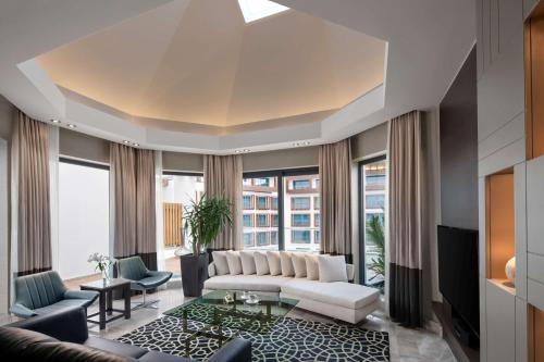 伊斯坦布尔伊斯坦布尔图兹拉丽笙酒店及水疗中心的客厅配有白色沙发和大窗户