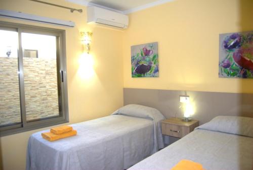 莫甘Villa Sunset Tauro的客房设有两张床和窗户。