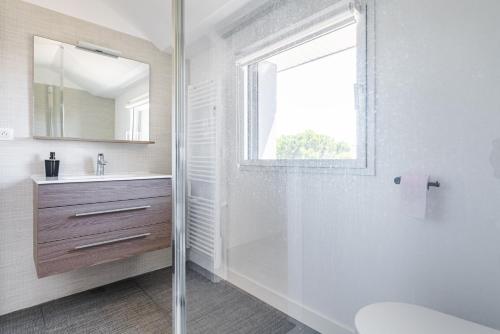 贝诺代Les Peupliers - maison de vacances avec jardin的带淋浴、盥洗盆和镜子的浴室