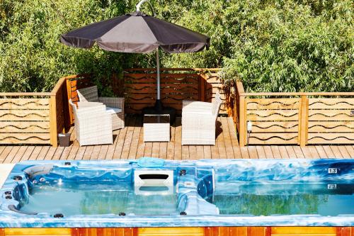 Chilia VecheCasa Chilia Resort&Spa的一个带遮阳伞和椅子及桌子的游泳池