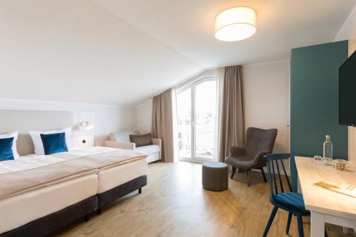 奥斯特巴德·哥伦Koopmanns Hotel und Lädchen的酒店客房设有一张大床和一张书桌。