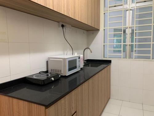 新山Tebrau City Residence,Warm Suite by Antlerzone的厨房的台面上配有微波炉