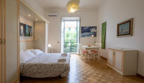 罗马ROMAMOREMIO的一间卧室配有一张床铺和一张桌子,还设有一间厨房