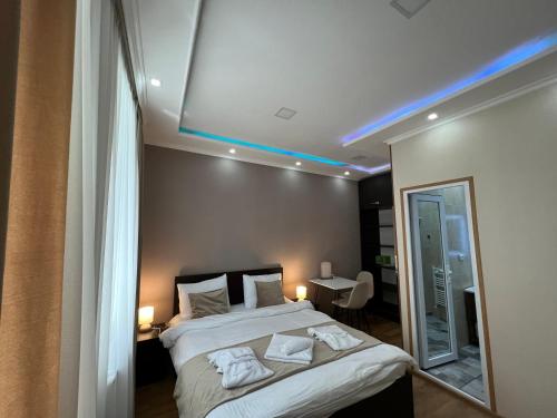 博尔若米Serenity Likani Villa Hotel的一间卧室设有一张天花板上蓝色灯光的床。