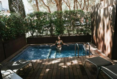 普拉加德阿罗NM Suites by Escampa Hotels的女人坐在游泳池里