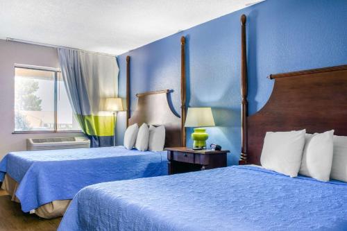 谢拉维斯塔Rodeway Inn near Ft Huachuca的两张位于酒店客房的床,拥有蓝色的墙壁