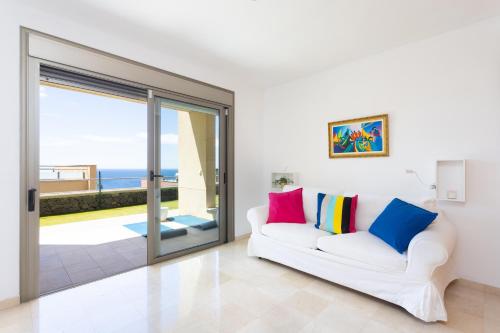 圣克鲁斯-德特内里费Chalet con vistas al mar en Santa Cruz de Tenerife的客厅配有白色沙发和滑动玻璃门