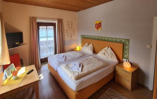 蒙德塞盖斯伯格膳食公寓的一间卧室配有一张床、一张书桌和一个窗户。