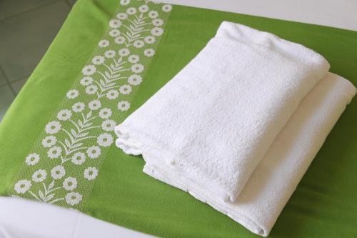 伊斯基亚松林酒店的绿色餐巾上方的白色毛巾