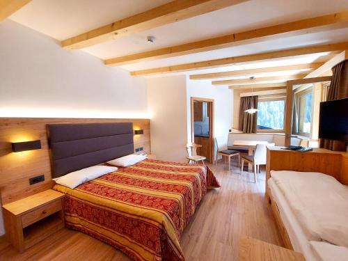 阿尔巴迪卡纳泽伊Appartamenti Arnica的一间卧室配有一张床、一张桌子和一张桌子