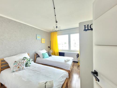 罗兹Pomorska Rooms的客房设有两张床和窗户。