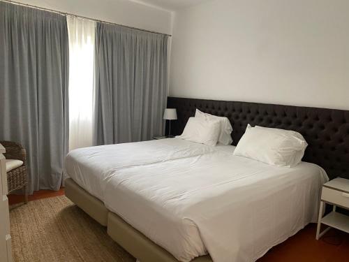金塔湖Quinta do lago & golf的卧室配有一张带白色床单和枕头的大床。