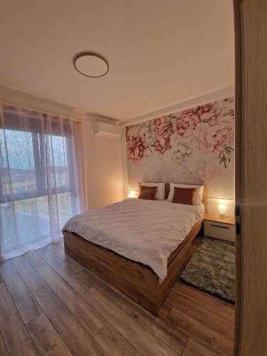 百乐费利克斯Blooming Apartment, Baile Felix的一间卧室配有一张带花卉墙壁的床