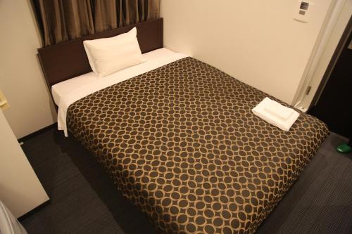 京都京都站前卓越酒店的一间卧室配有一张带棕色棉被的床