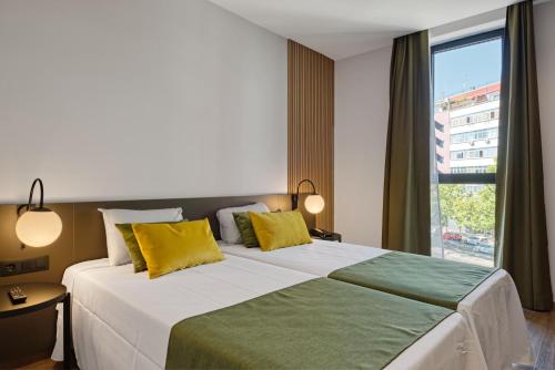 马德里DWO Colours Alcalá的一间卧室配有一张大床,提供黄色和绿色的枕头