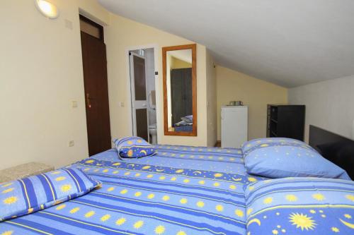 奈维斯Double Room Njivice 5458a的一间卧室配有一张大床,提供蓝色的床单和枕头