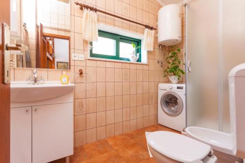马卡尔斯卡Apartments and rooms with WiFi Makarska - 11063的浴室配有卫生间、盥洗盆和洗衣机。