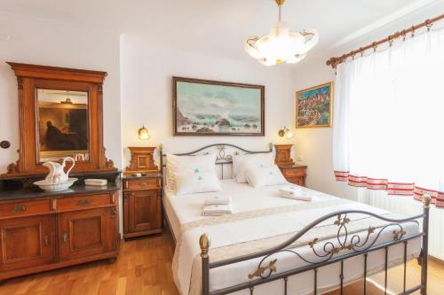 马卡尔斯卡Apartments and rooms with WiFi Makarska - 11063的一间卧室配有一张床、镜子和吊灯