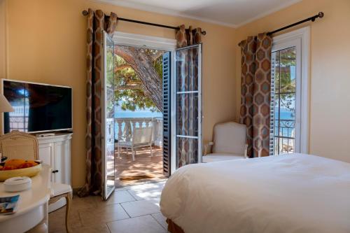 阿雅克修Hôtel Les Mouettes - Teritoria的一间卧室设有一张床和一个滑动玻璃门