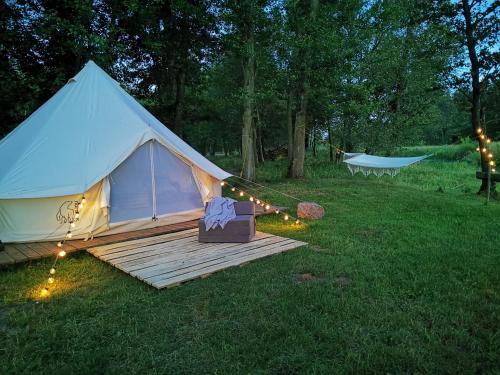 沃胡夫Glamping Kaliska的白色帐篷,设有木甲板,位于草地上