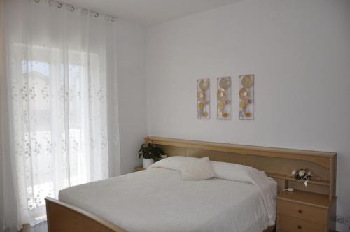 加尔达湖滨Appartamento Alba的卧室配有白色的床和窗户。