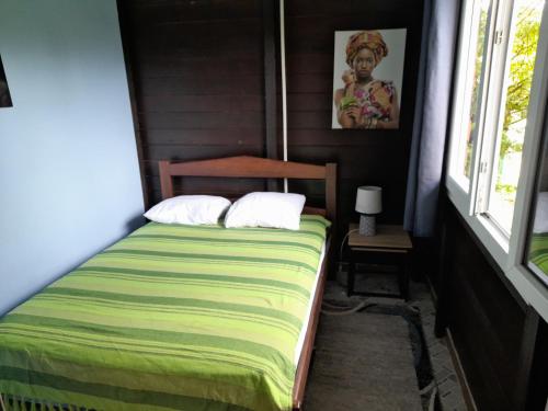 MatouryCharmant Lodge tout confort的一间小卧室,配有床和窗户