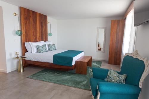 Santa BárbaraCasa dos Romeiros的一间卧室配有一张床和一张蓝色椅子