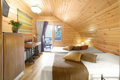 沃卡蒂沃卡蒂艾特利马尔萨卡别墅的小木屋内一间卧室,配有两张床