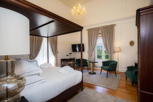 阿尔库什迪瓦尔德维什Solar do Requeijo by Luna Hotels & Resorts的一间卧室配有一张大床和一张桌子及椅子