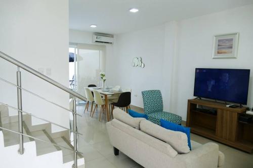 普拉亚斯Ecusuites Playas House III Resort Altamar 45Min GYE的带沙发、电视和桌子的客厅