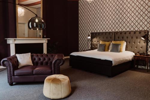 SchiphorstChâteauhotel De Havixhorst的一间卧室配有一张床、一张沙发和一把椅子