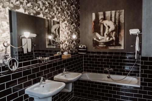 SchiphorstChâteauhotel De Havixhorst的浴室配有两个盥洗盆和浴缸。