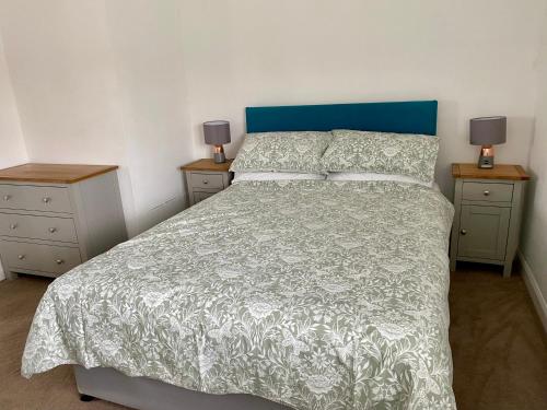 WitleySunnyhill的一间卧室配有一张带蓝色床头板和2个床头柜的床。